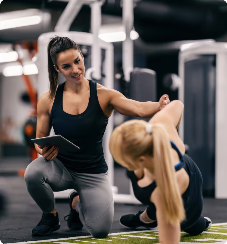 personal trainer helping the client do the gym workout the right way