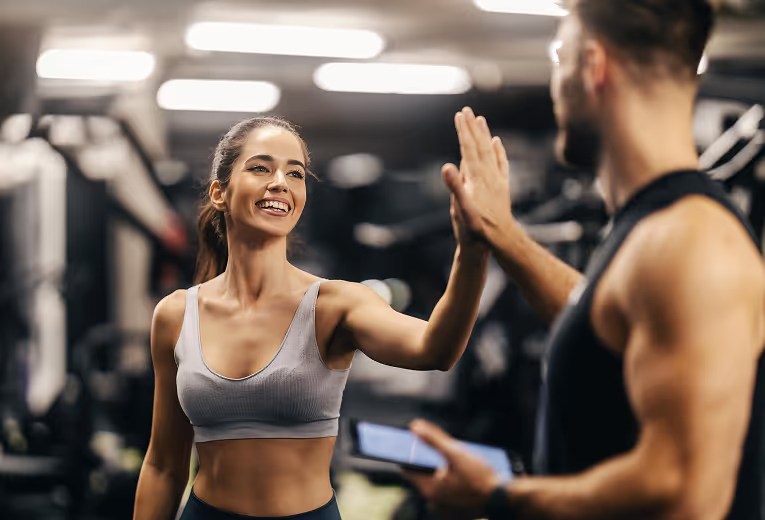 Coach high fives the client after a workout